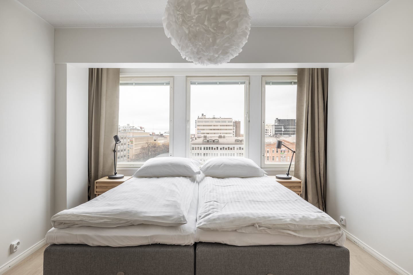 Bedroom with white linens and city views